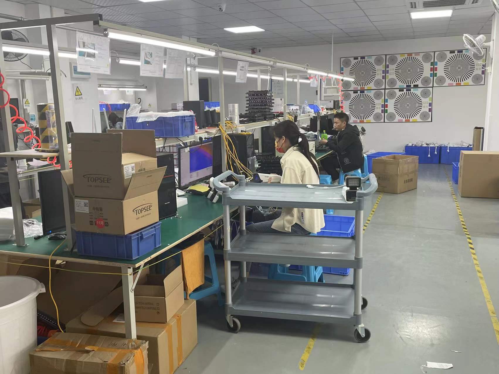 CCTV camera assembly workshop with technicians and prepared housings